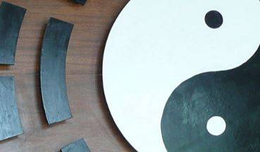 Dieses Bild zeig einen Ausschnitt der klassischen Yin-Yang Darstellung: ein Kreis welcher durch den Buchstaben S in zwei geteilt ist. Die weisse Hälfte beinhaltet einen kleinen schwarzen Punkt, die schwarze Hälfte einen kleinen weissen Punkt. 