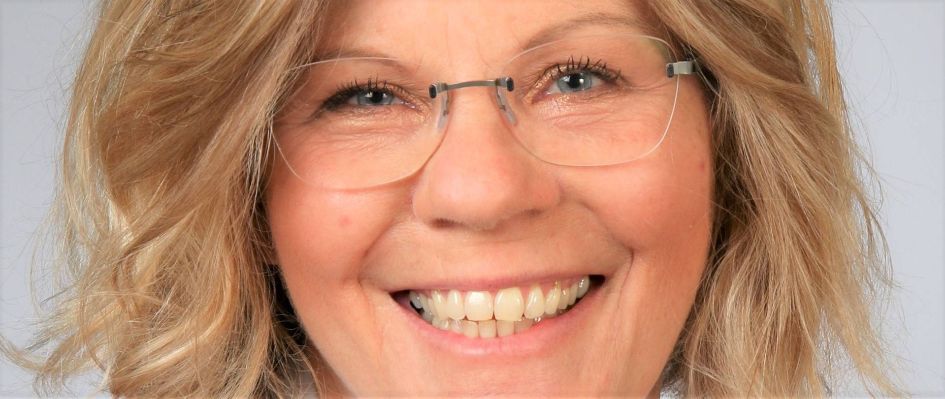 Bei diesem Bild handelt es sich um ein Portrait von Ursula Reber, Feng Shui Beratung résonance. Sie hat blonde, mittellange Haare, blaue Augen und trägt eine randlose Brille. 